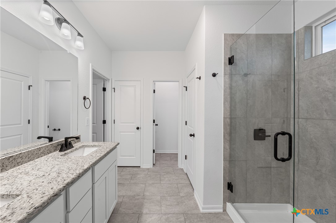 8011 Pineridge Way Temple, TX 76502 - Photo 27 of 32 a bathroom with a granite countertop sink and shower