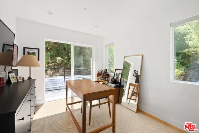 a view of a workspace with furniture and a window