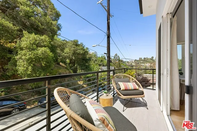 a view of a balcony with wooden floor and outdoor seating