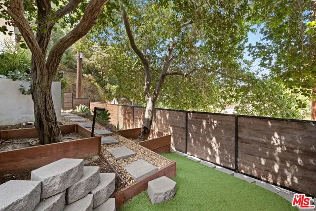 a view of a balcony with chairs and wooden fence