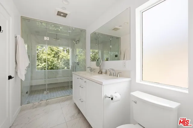 a bathroom with a granite countertop sink toilet and shower