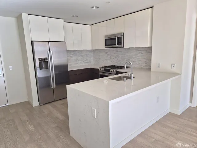 a kitchen with stainless steel appliances a refrigerator sink microwave and cabinets