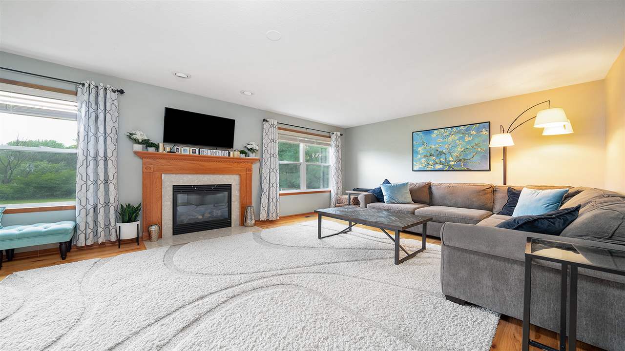 10997 Chicory Ridge Way Roscoe, IL 61073 - Photo 8 of 36 a living room with furniture a flat screen tv and a fireplace