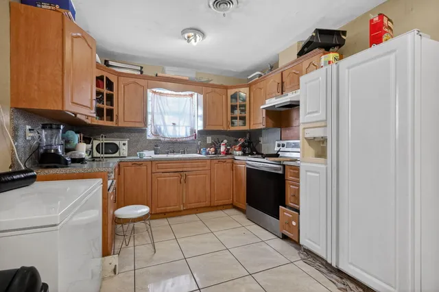 a kitchen with stainless steel appliances granite countertop a refrigerator and a stove top oven