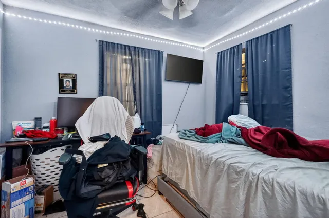 a bedroom with a bed and a flat tv screen