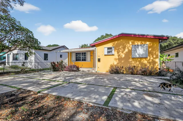 a view of a house with backyard and sitting area