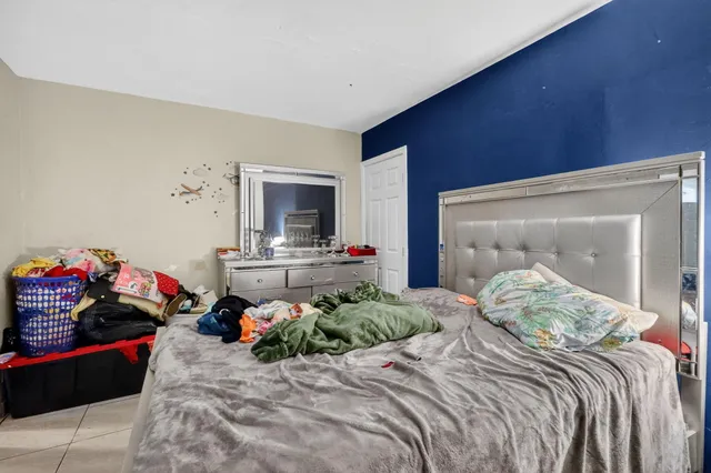 a bedroom with a bed and a tv on dresser