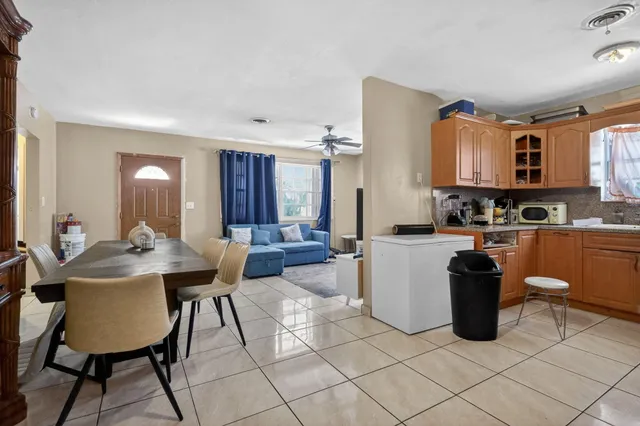 a kitchen with a sink dining table and chairs