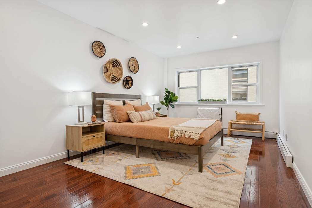 27-16 41st Avenue, Unit 3D Queens, NY 11101 - Photo 6 of 14 a living room with a bed furniture and a large window
