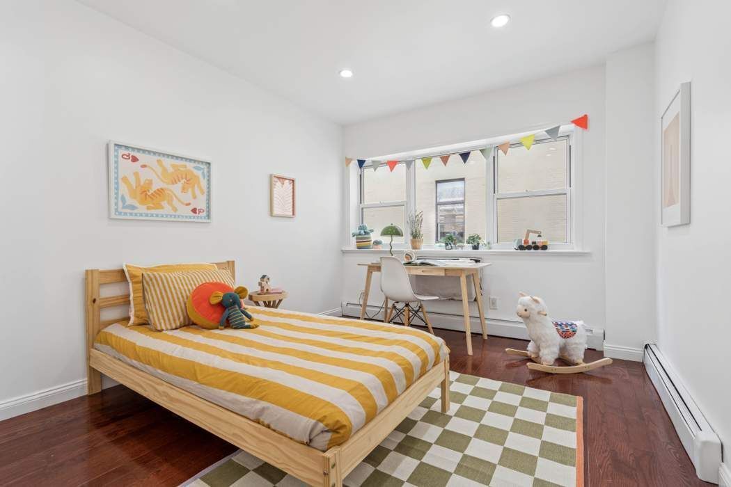 27-16 41st Avenue, Unit 3D Queens, NY 11101 - Photo 9 of 14 a bedroom with a bed and wooden floor