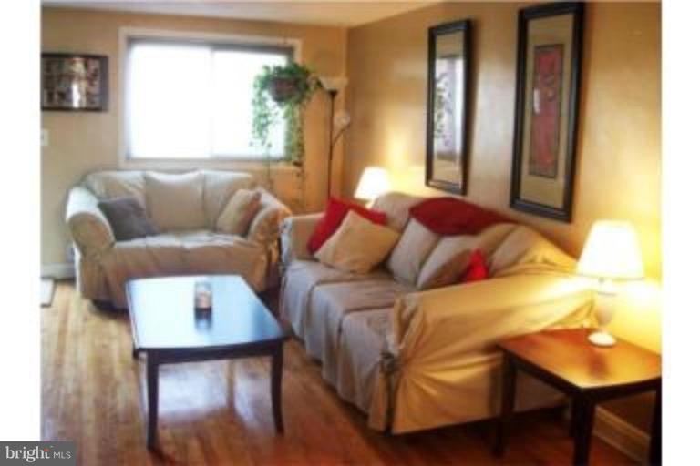1363 Kenton Road Parkville, MD 21234 - Photo 2 of 9 a living room with a bed and a couch next to a window