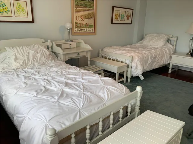 a spacious bedroom with two beds and a desk