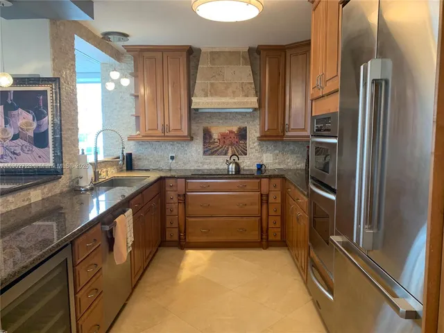 a kitchen with granite countertop a refrigerator sink and stove
