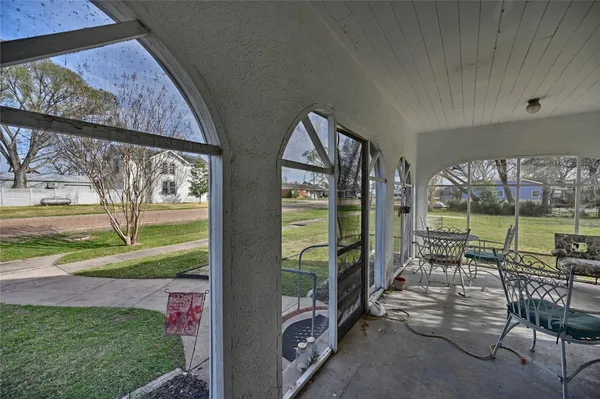 a view of a porch with furniture and garden