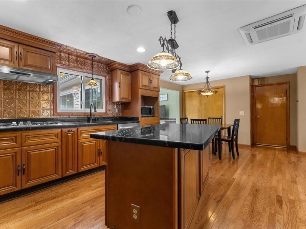 11 Benson Street Worcester, MA 01604 - Photo 4 of 40 a kitchen with granite countertop a stove a sink a center island and wooden floor