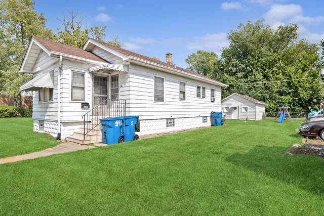 a view of a house with a backyard and a tree