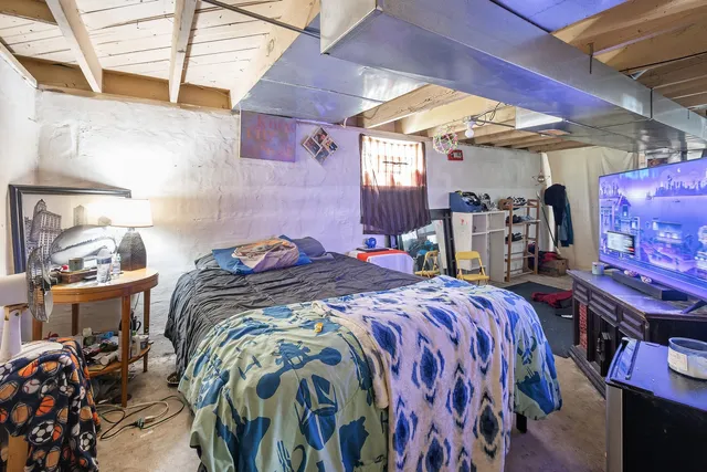 a bed sitting in a bedroom next to a window