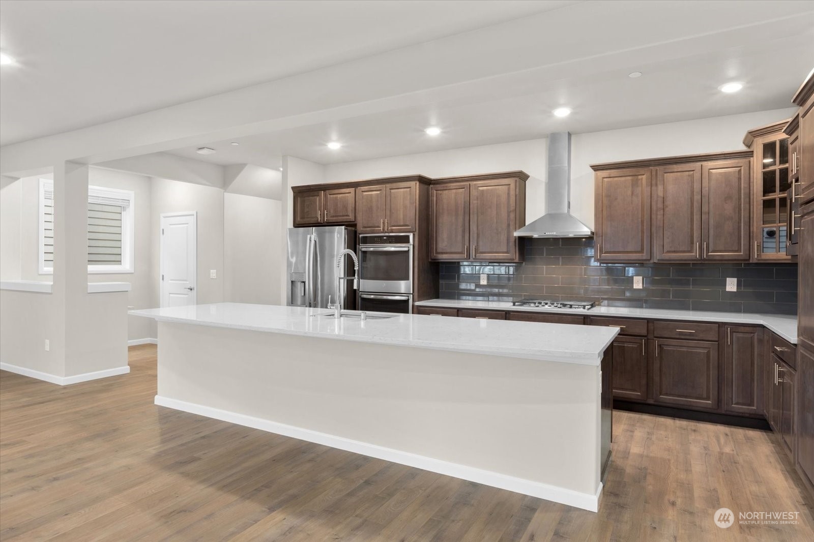 4308 233rd Place Southeast Bothell, WA 98021 - Photo 10 of 39 a large kitchen with stainless steel appliances kitchen island granite countertop a stove a sink a refrigerator and white cabinets