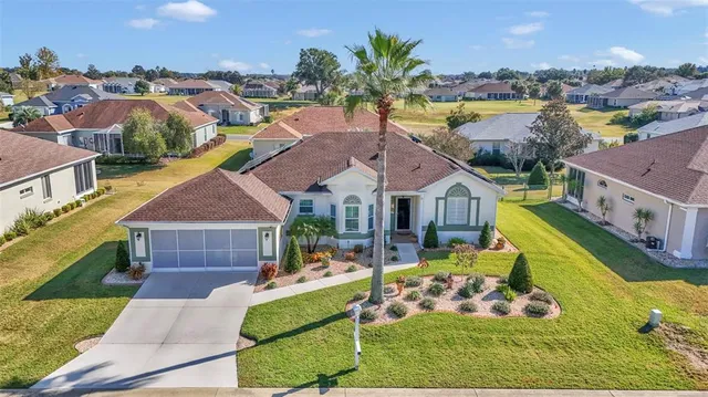 a aerial view of a house with swimming pool lawn chairs and a yard