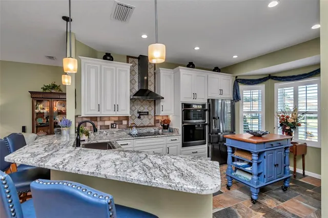 a kitchen with kitchen island granite countertop wooden cabinets and a refrigerator