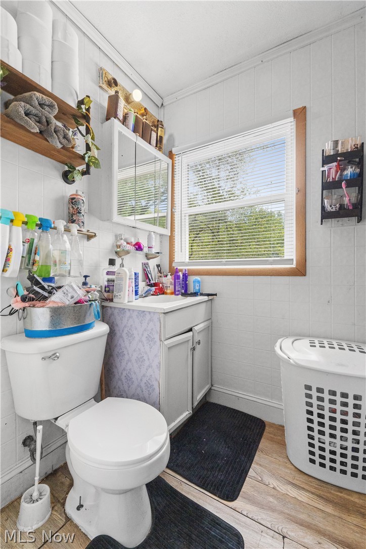 68-70 East Sunset Drive Rittman, OH 44270 - Photo 12 of 49 Bathroom featuring a window with blinds, a wall-mounted medicine cabinet, and a white vanity with cabinet storage