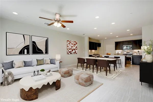 a living room with furniture and view of kitchen