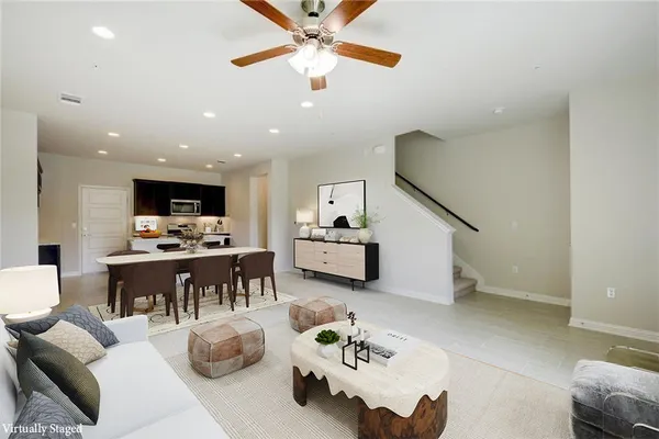 a living room with furniture kitchen view and a chandelier