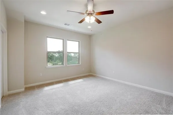 an empty room with a window and a fan