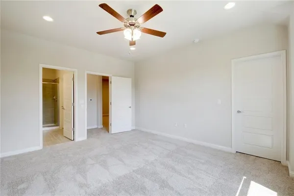 an empty room with closet and a ceiling fan
