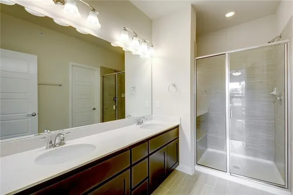 a bathroom with a double vanity sink mirror and shower