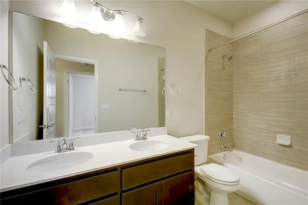 a bathroom with a granite countertop sink toilet a mirror and shower