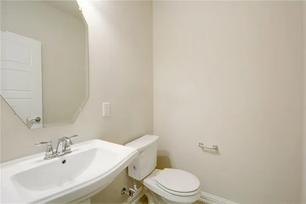 a bathroom with a sink a toilet and mirror
