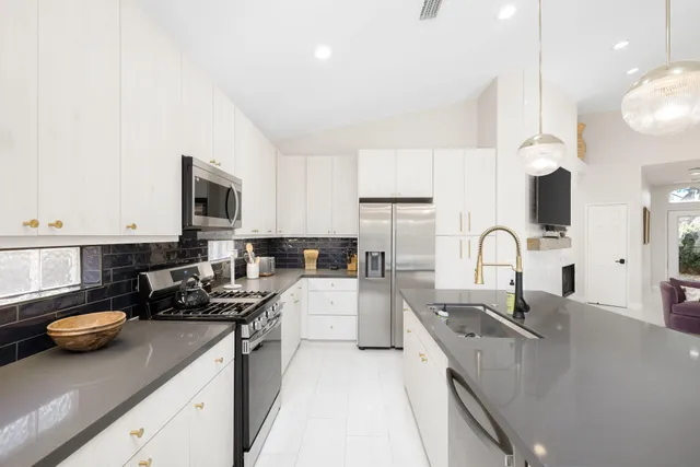 a kitchen with refrigerator a stove and a sink