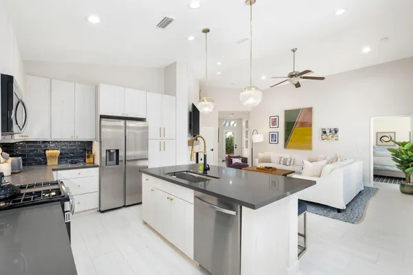 a kitchen with a table chairs and white cabinets