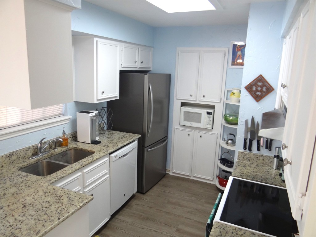 1005 North LBJ Drive, Unit B2 San Marcos, TX 78666 - Photo 2 of 13 a kitchen with a refrigerator and a sink