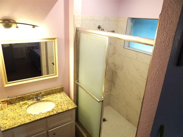 a bathroom with a granite countertop sink and a mirror