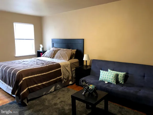 a bedroom with a bed window and couch