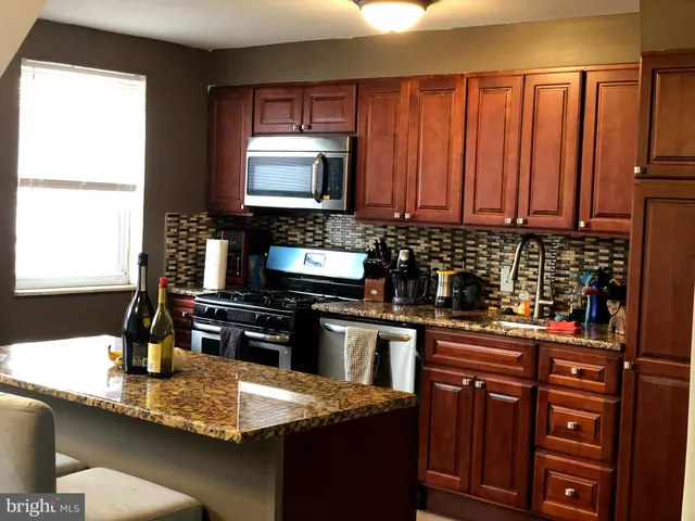 a kitchen with stainless steel appliances granite countertop a sink stove and microwave