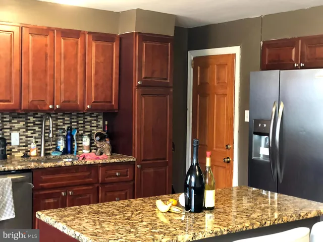 a kitchen with stainless steel appliances granite countertop a refrigerator and a stove