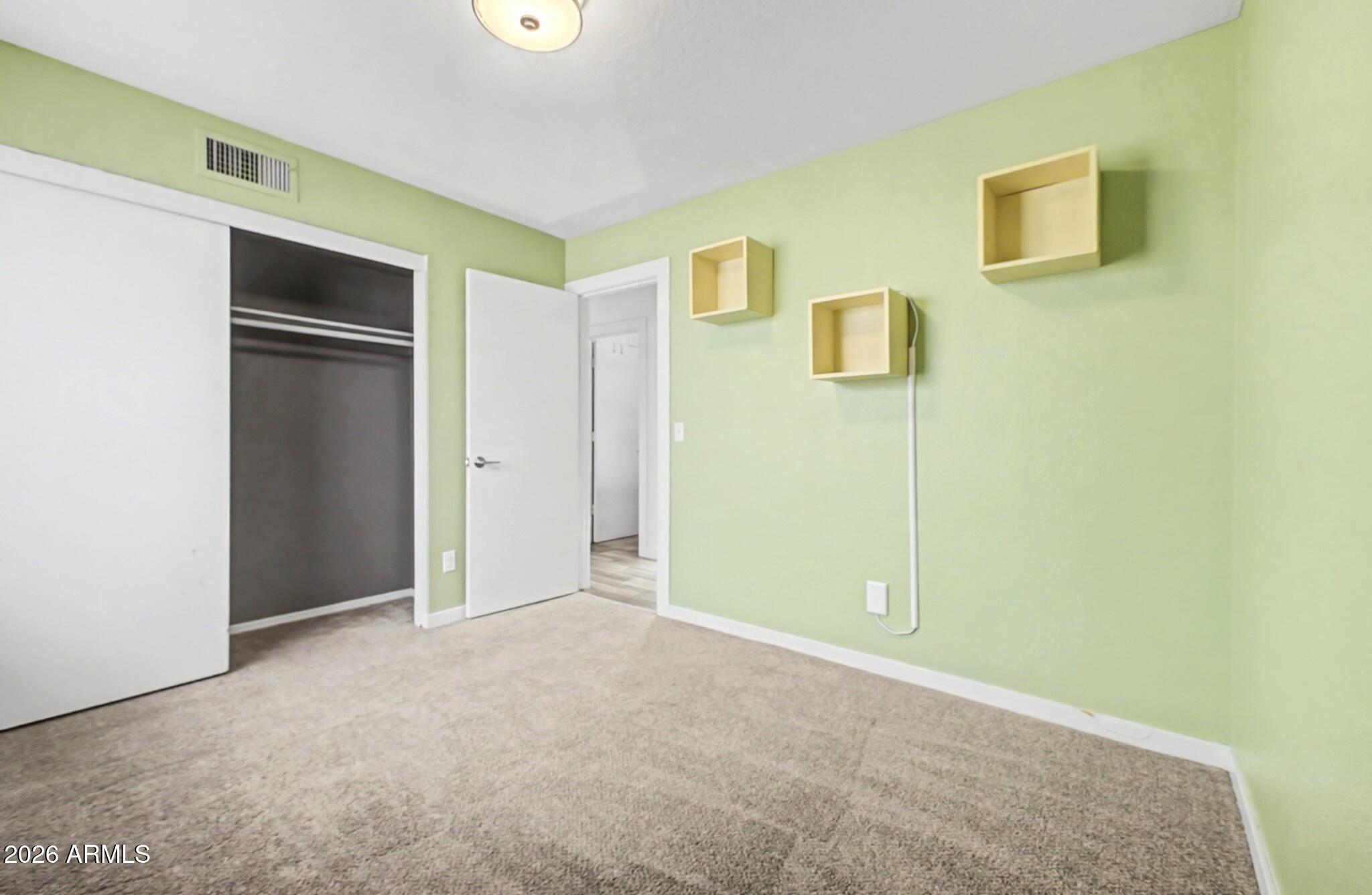 109 West Mohawk Lane Phoenix, AZ 85027 - Photo 14 of 23 a view of an empty room with closet and wooden floor