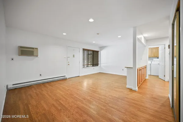 a view of a big room with wooden floor and a bathroom