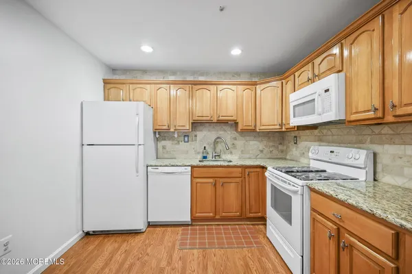 a kitchen with stainless steel appliances granite countertop a refrigerator sink and stove