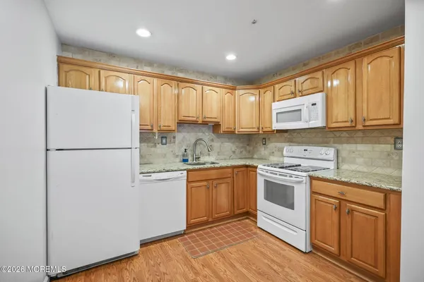 a kitchen with stainless steel appliances granite countertop a refrigerator a stove a sink and a microwave