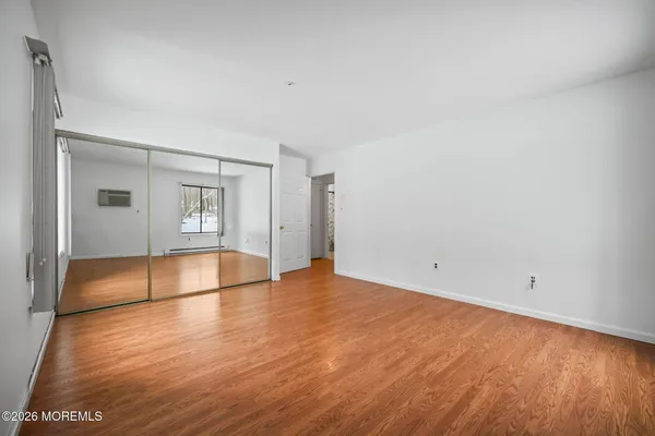 a view of empty room with wooden floor