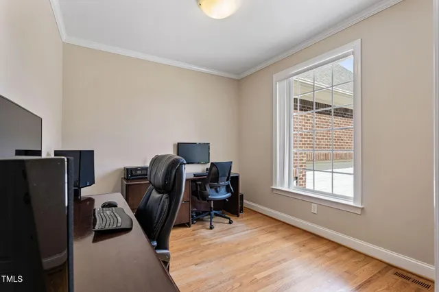 a bedroom with a bed and a flat tv screen on a dresser