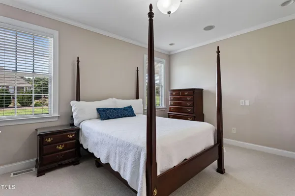a bedroom with a bed dresser and a window