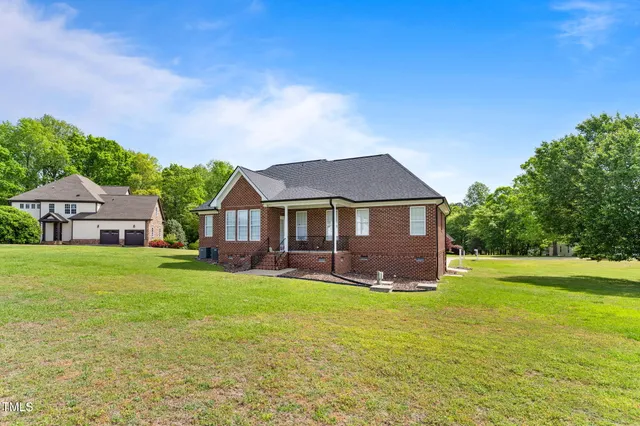 a front view of a house with a garden and yard