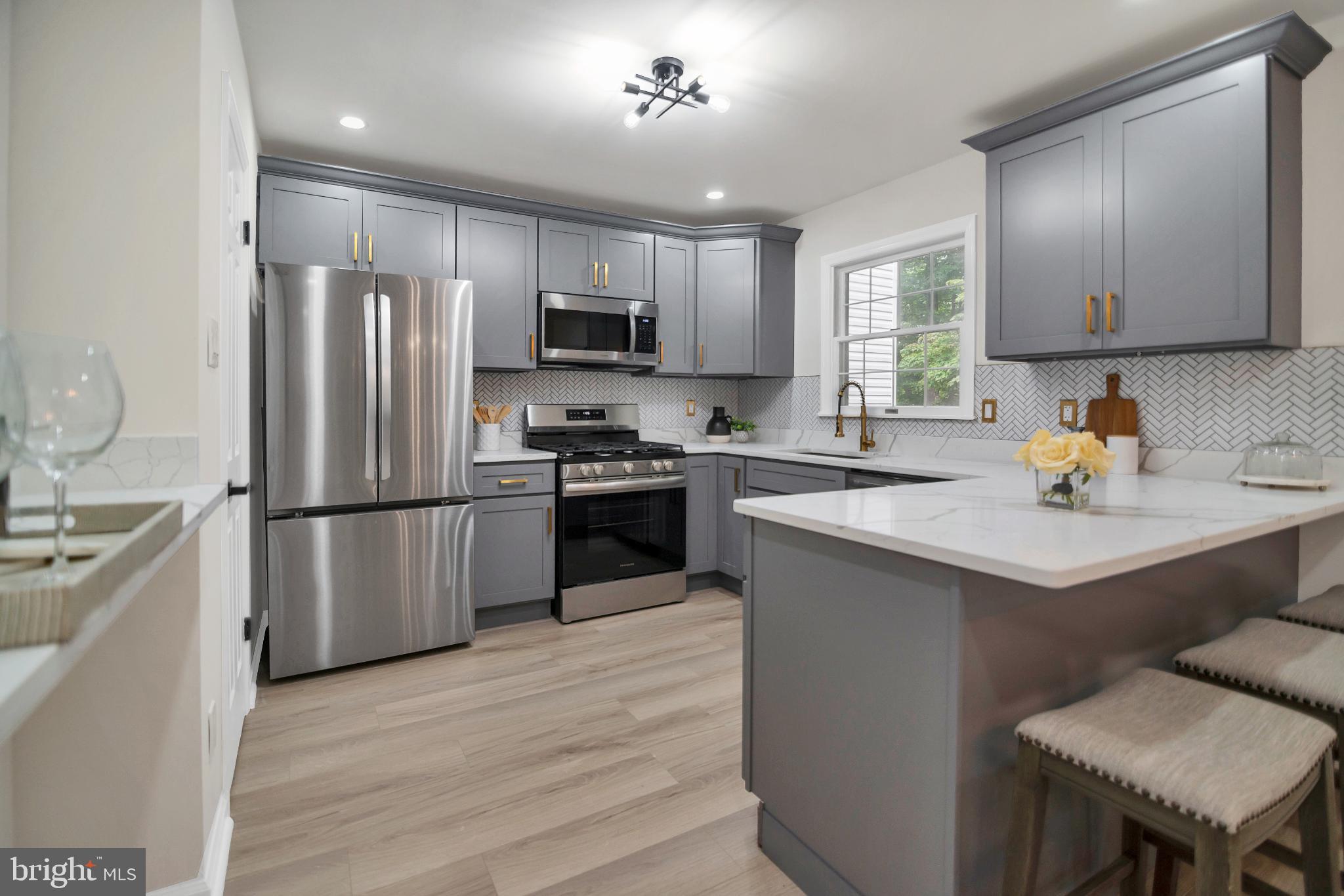 5809 Shana Place Burke, VA 22015 - Photo 11 of 46 a kitchen with stainless steel appliances a refrigerator a sink a stove a table and chairs