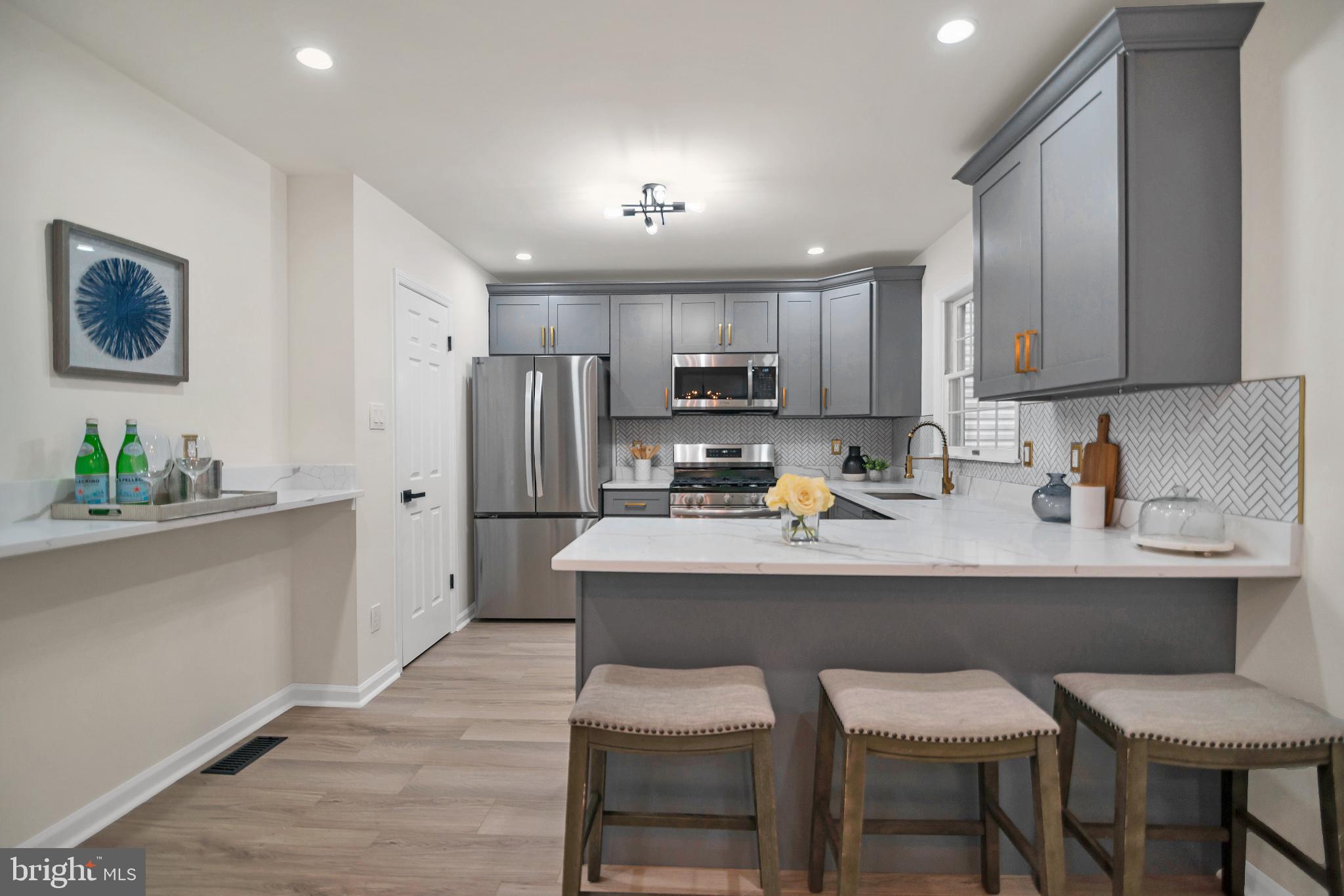 5809 Shana Place Burke, VA 22015 - Photo 12 of 46 a kitchen with kitchen island a white cabinets and refrigerator