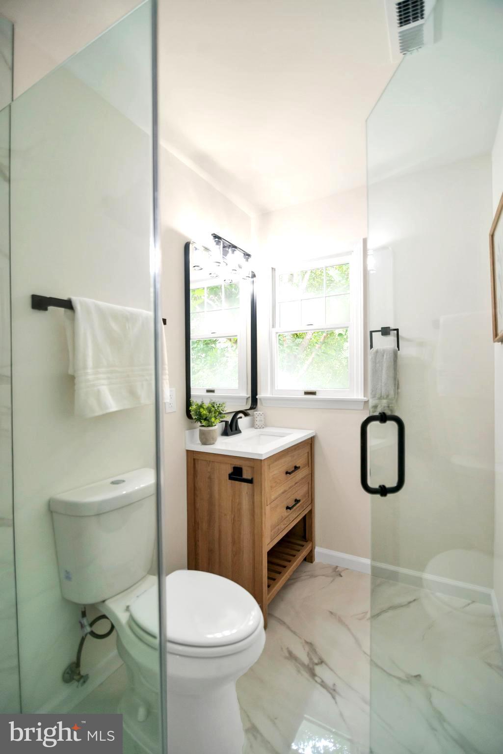 5809 Shana Place Burke, VA 22015 - Photo 28 of 46 a bathroom with a granite countertop toilet sink and mirror